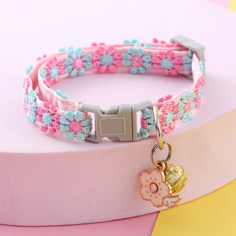 Colorful braided cat collar with a decorative charm on a pink background
