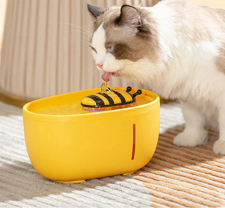 Cat drinking from a yellow water bowl with text about high capacity and convenience.